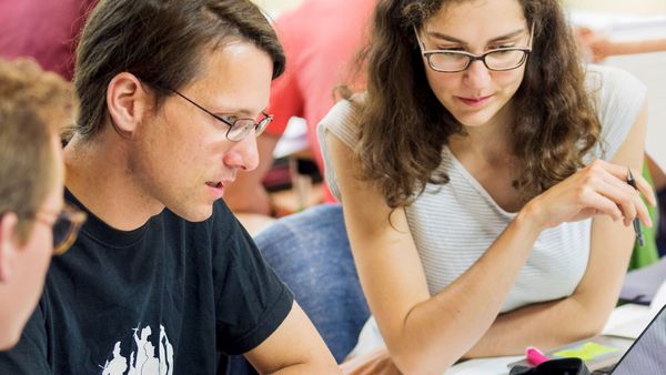 Future veterinarian Aline Steiner (right) and other students try their hand at something new: designing a fair healthcare system on a tight budget.