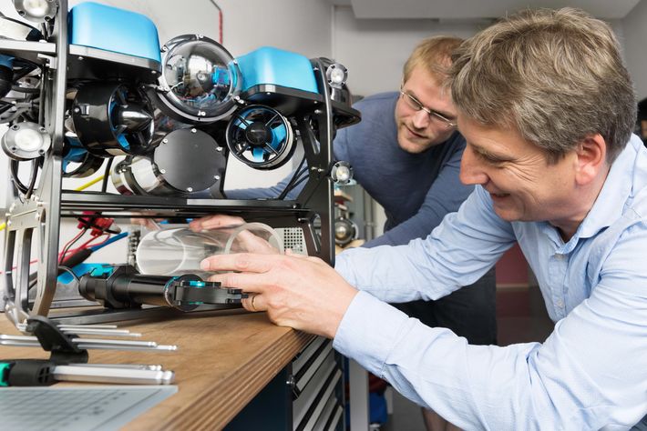 Werner Siemens-Stiftungsprofessor Ralf Bachmayer (rechts) und sein Mitarbeiter Paul Riesen überprüfen das zusätzliche Druckgehäuse eines neuen optischen Sensors auf einem kleinen, ferngesteuerten Unterwasserfahrzeug.